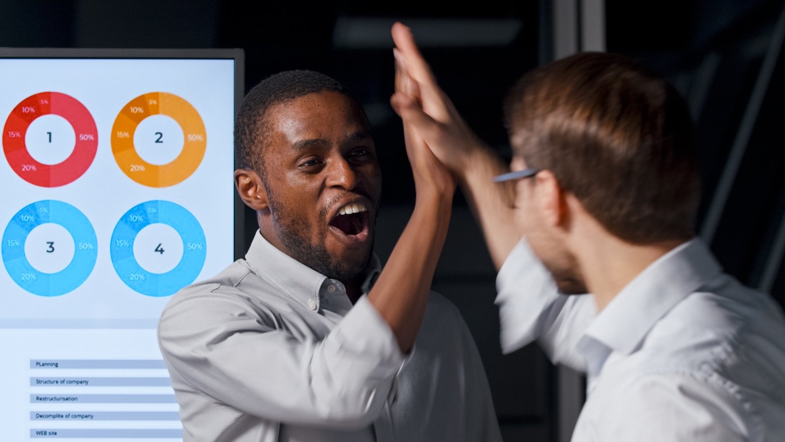 Happy business colleagues on the background of infographics in the office